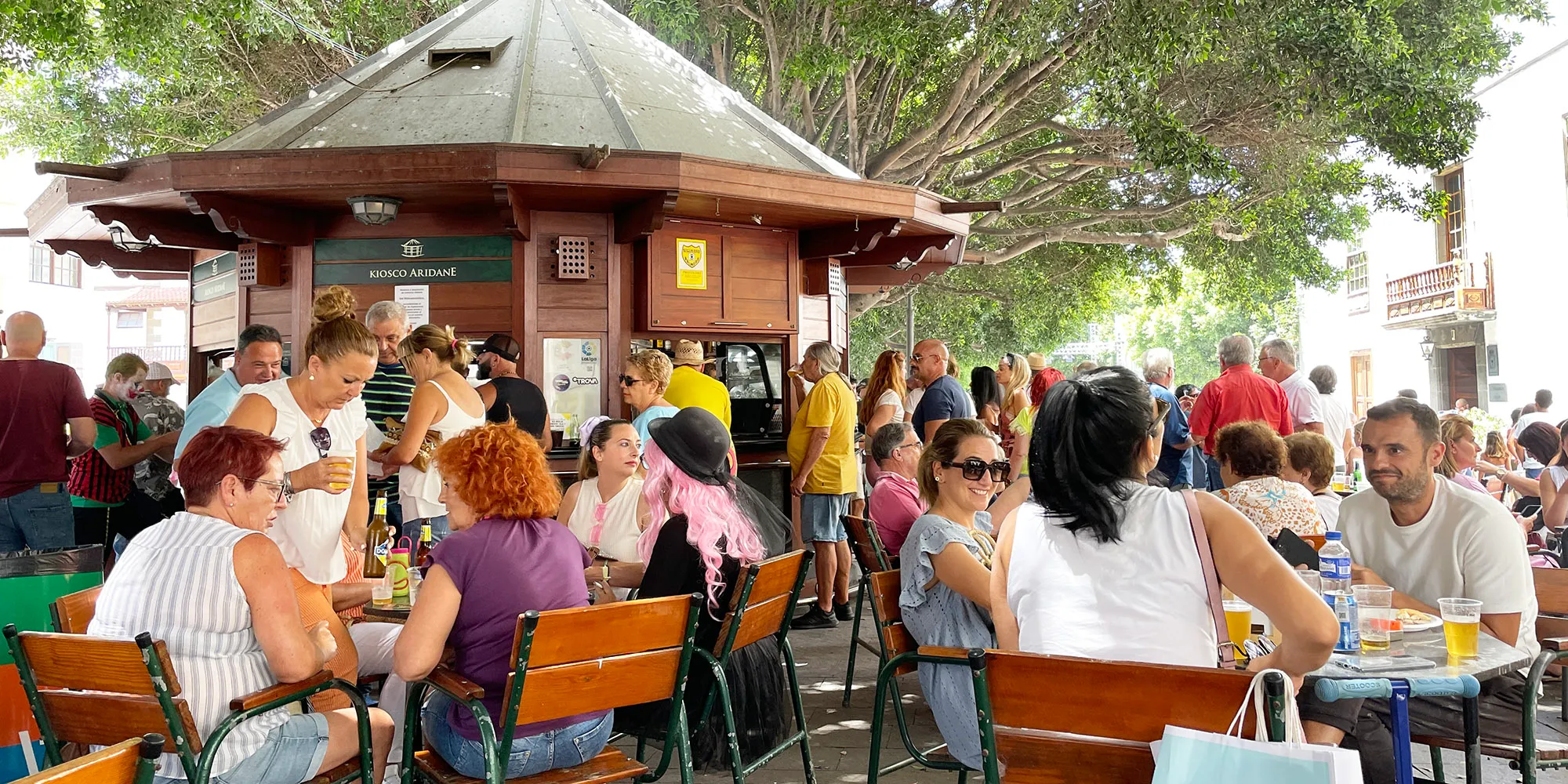 Plaza de un municipio con ciudadanía, comercio local y actividad urbana